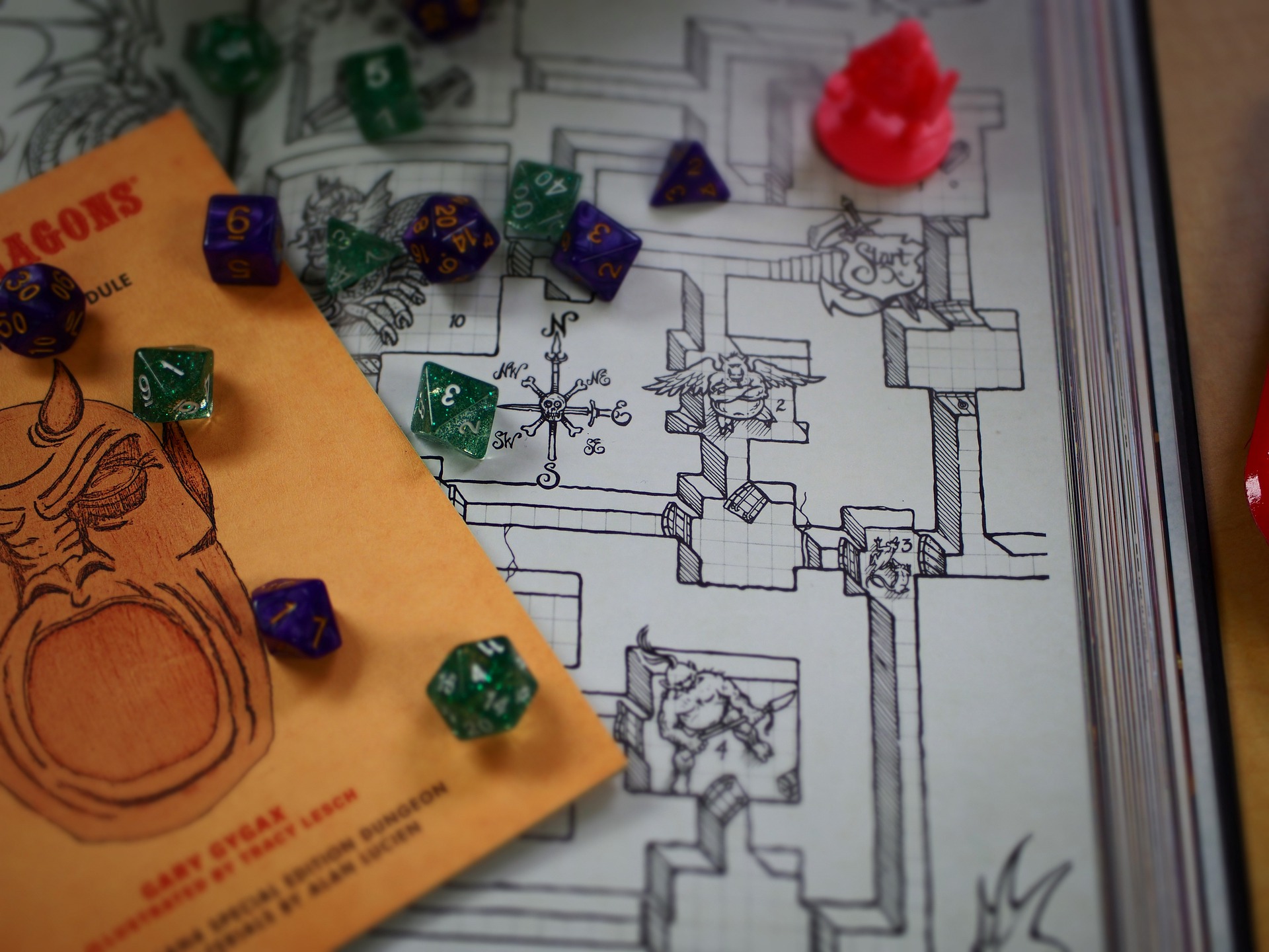 Dice scattered over a dungeon map and a copy of an old D&D rules booklet.